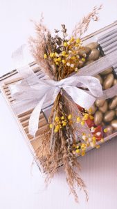 Stylish gift box adorned with a silver bow and dried flowers, perfect for celebrations.