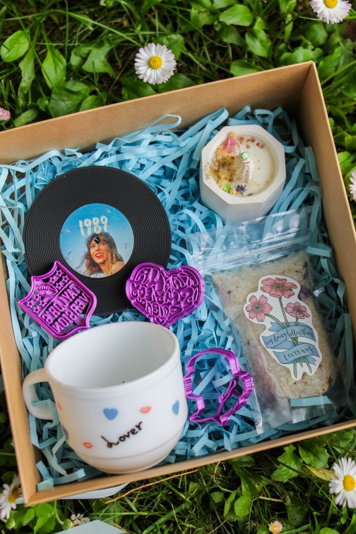 Charming gift box with vinyl record, mug, and bath products on grass, perfect for music lovers.